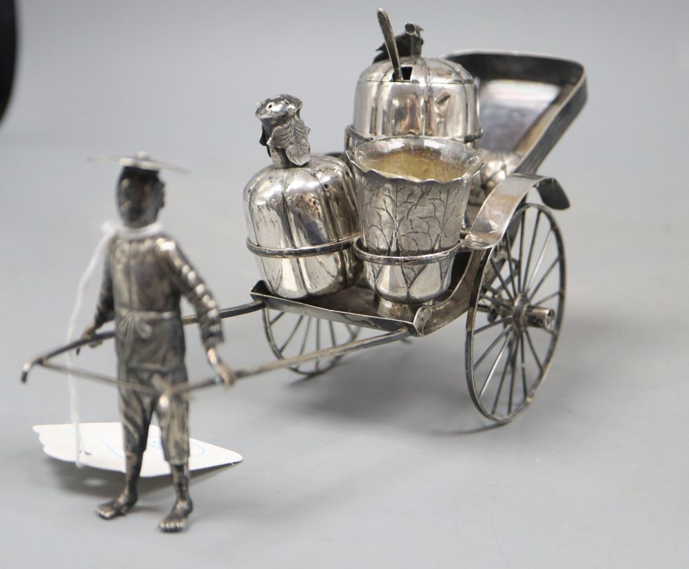 An early 20th century Chinese Export white metal cruet stand, modelled as a rickshaw, maker KC, length 21.5cm.